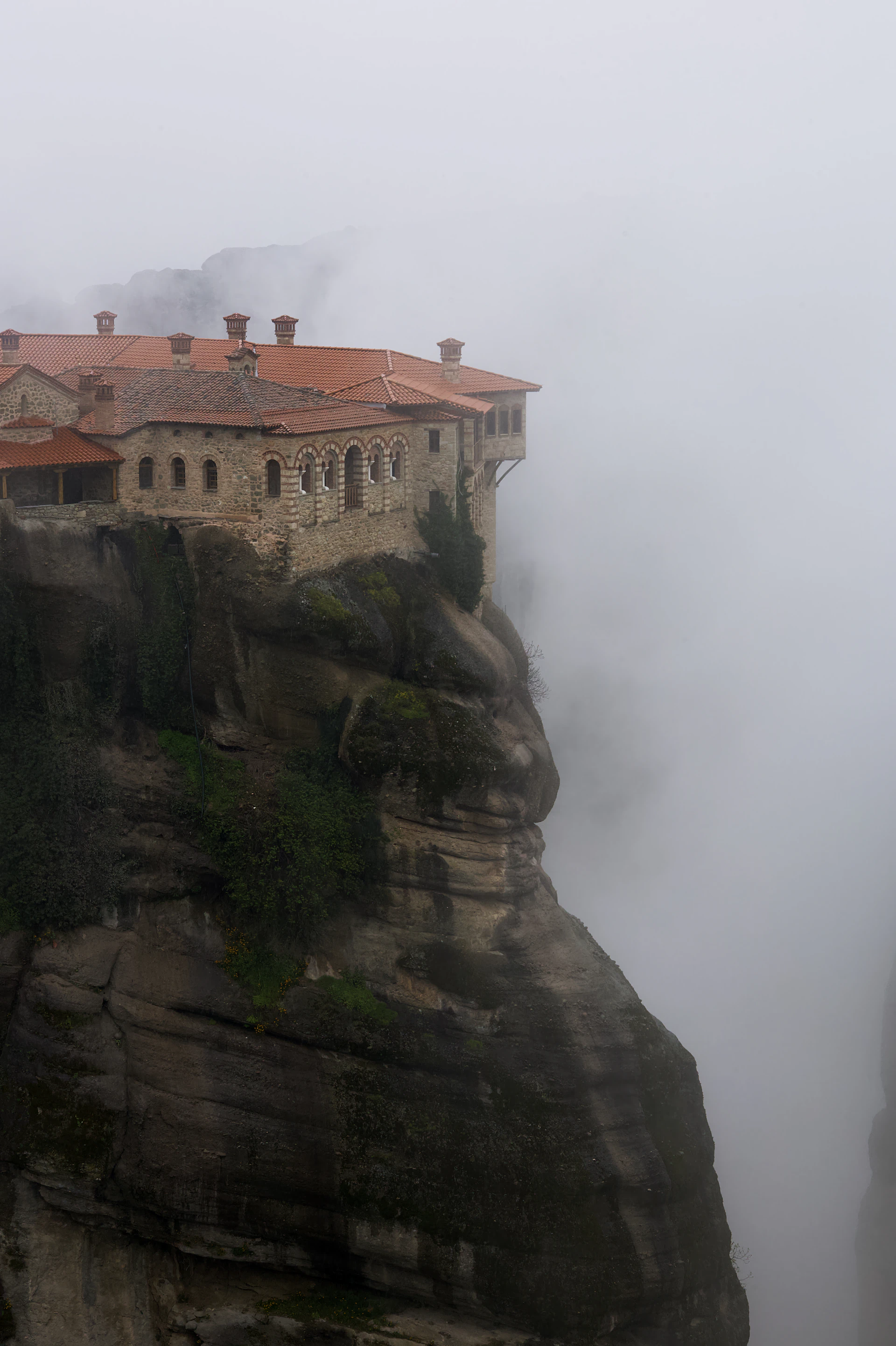 a castle on top of a cliff in the fog