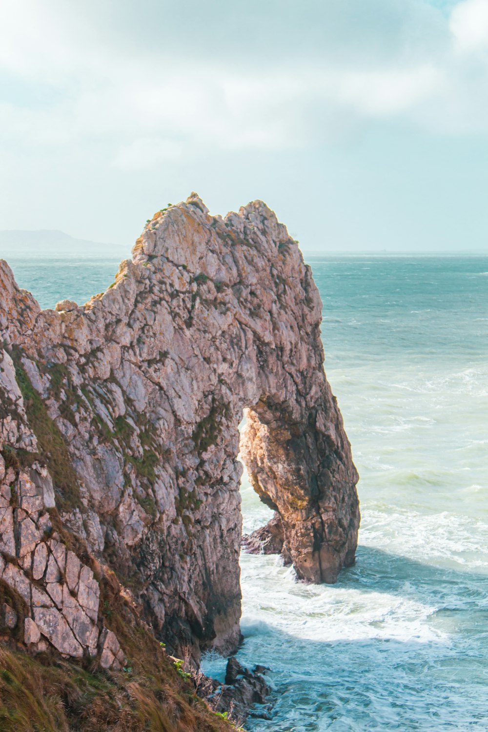 a large rock sticking out of the ocean