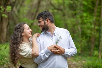 a man and a woman standing in the woods