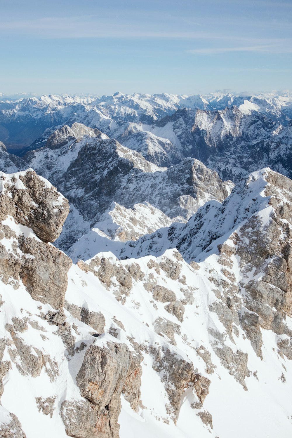 um homem de pé no topo de uma montanha coberta de neve