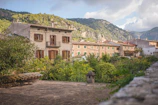 Charming Albanian village with stone houses and mountain backdrop.