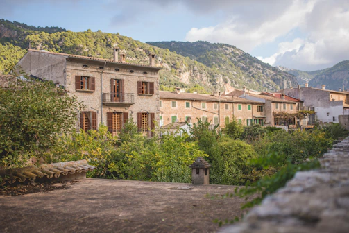 Charming Albanian village with stone houses and mountain backdrop.