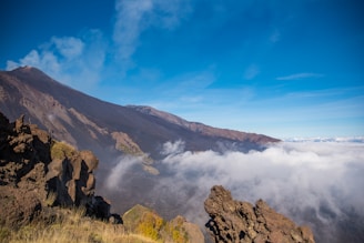a view of the top of a mountain in the clouds