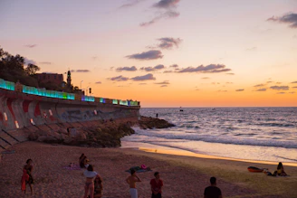 Sunset view of Puri Beach with pilgrims walking along the shore.