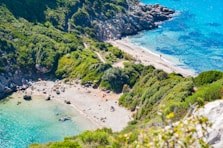 an aerial view of a sandy beach with blue water