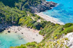 an aerial view of a sandy beach with blue water