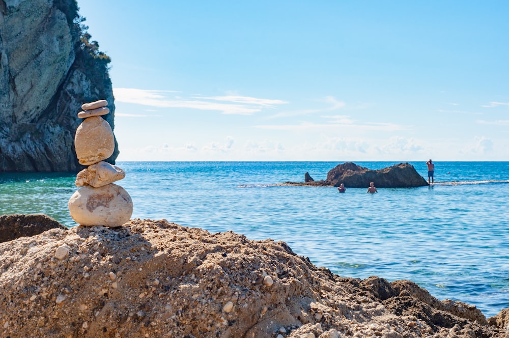 a stack of rocks sitting on top of a beach next to the ocean