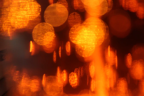 Artisan paper texture with soft burnt orange and mustard gold bokeh lights creating a warm, inviting glow.