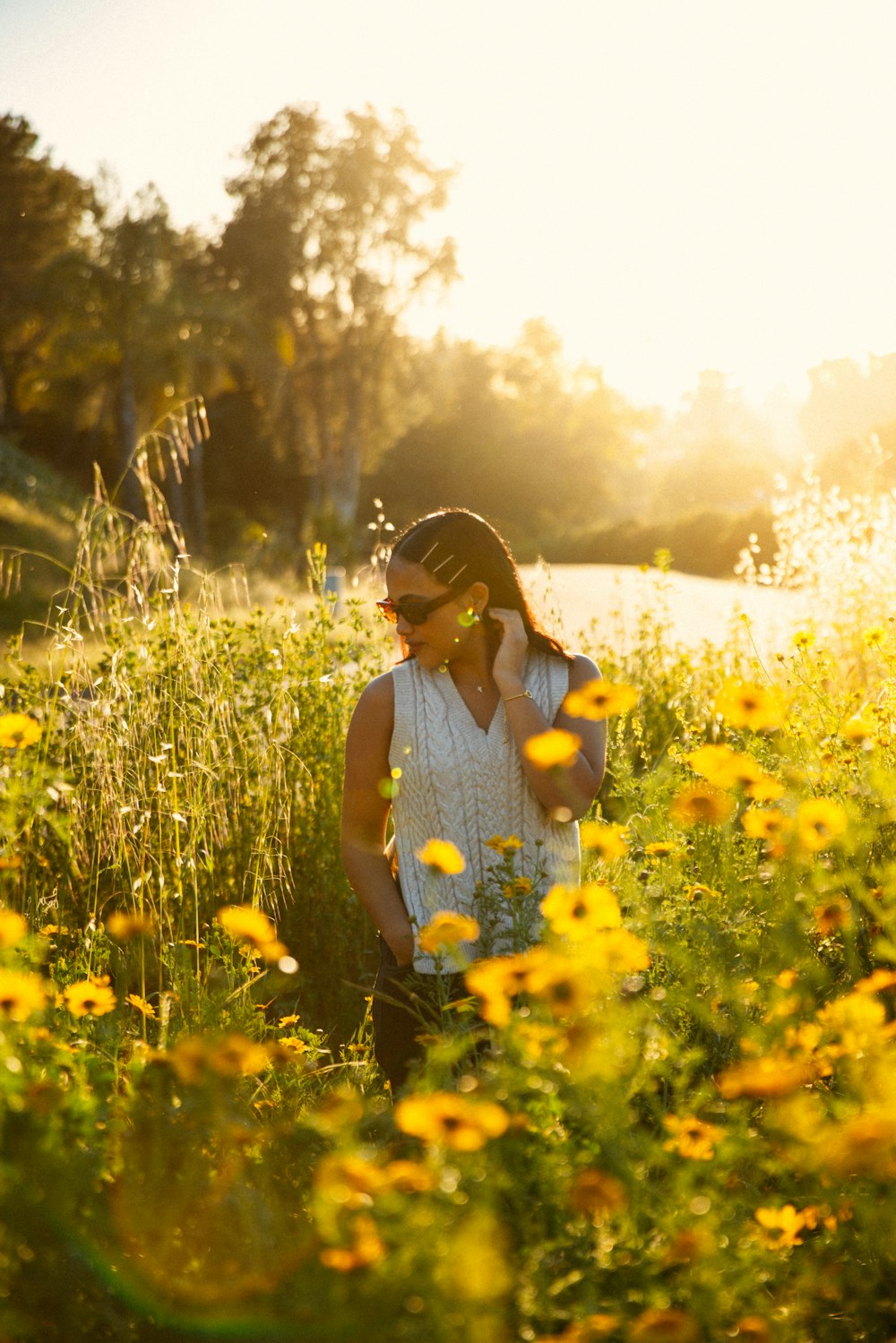 a woman standing in a field of yellow flowers