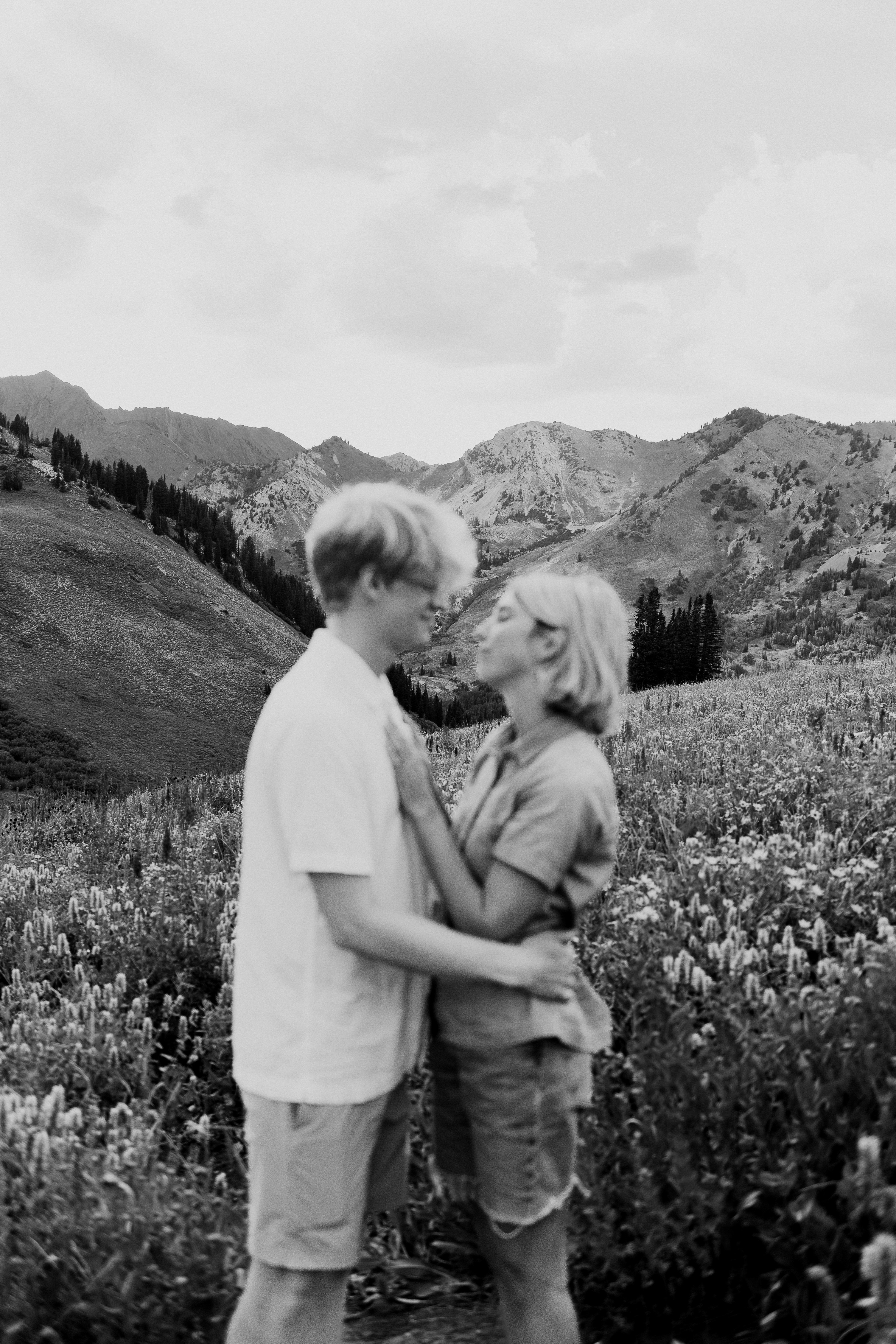 a man and woman standing in a field of flowers