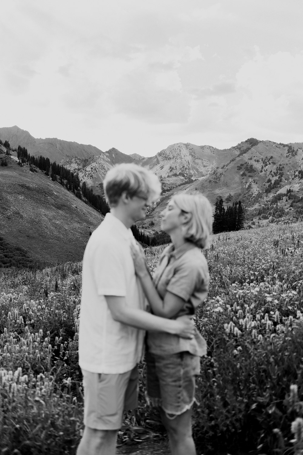 a man and woman standing in a field of flowers