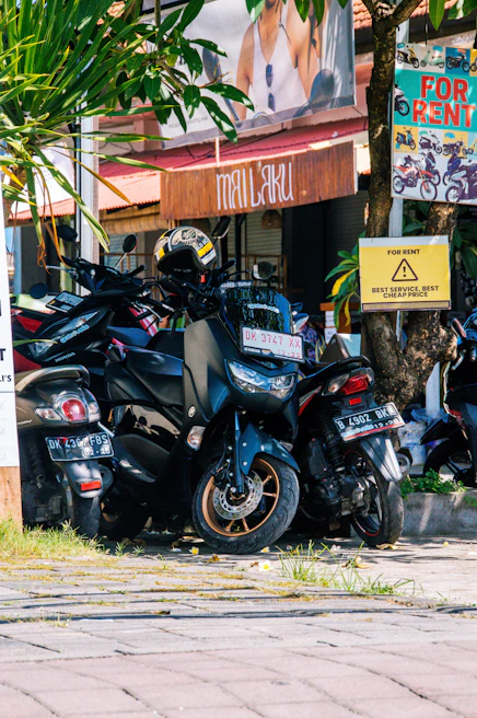 A row of colorful motorbikes lined up outside the Looknok Car Rental office in Sakhu