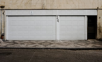 two white garage doors in front of a building