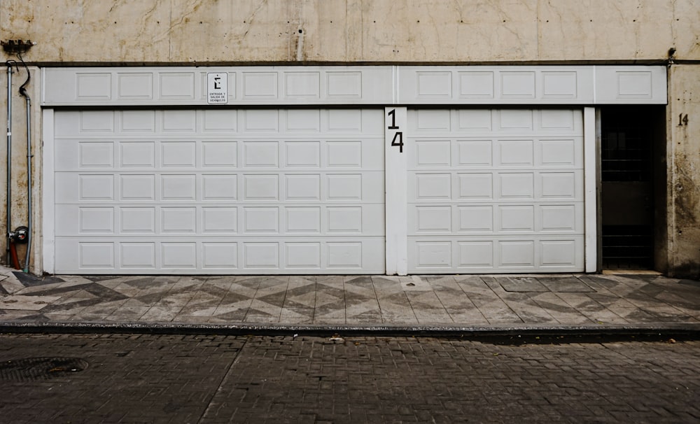 Due porte bianche del garage di fronte a un edificio