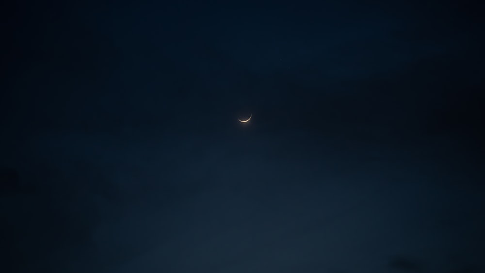 the moon is seen through the clouds in the night sky