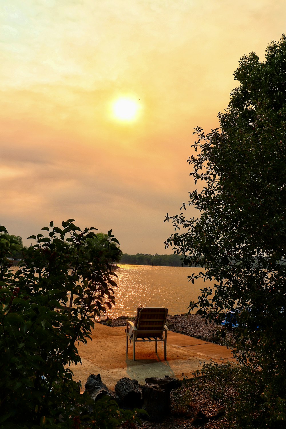 a wooden chair sitting on top of a sandy beach