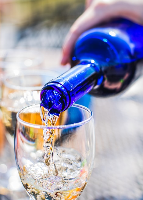 A close-up of a wine bottle being poured into a glass.