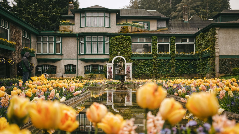 uma casa com um jardim de flores em frente a ela
