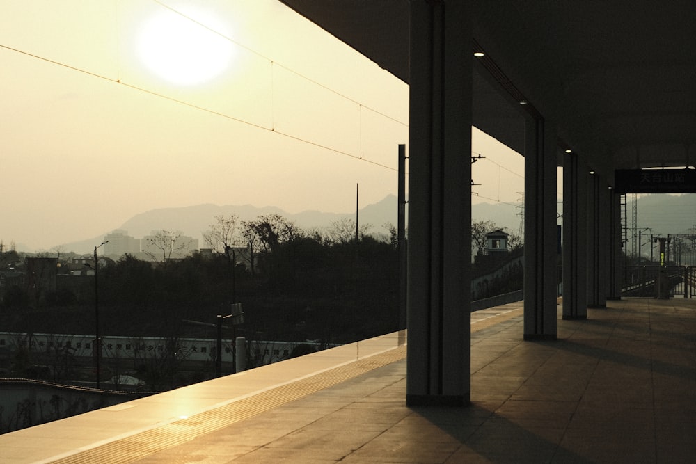 the sun is setting over a city with mountains in the background