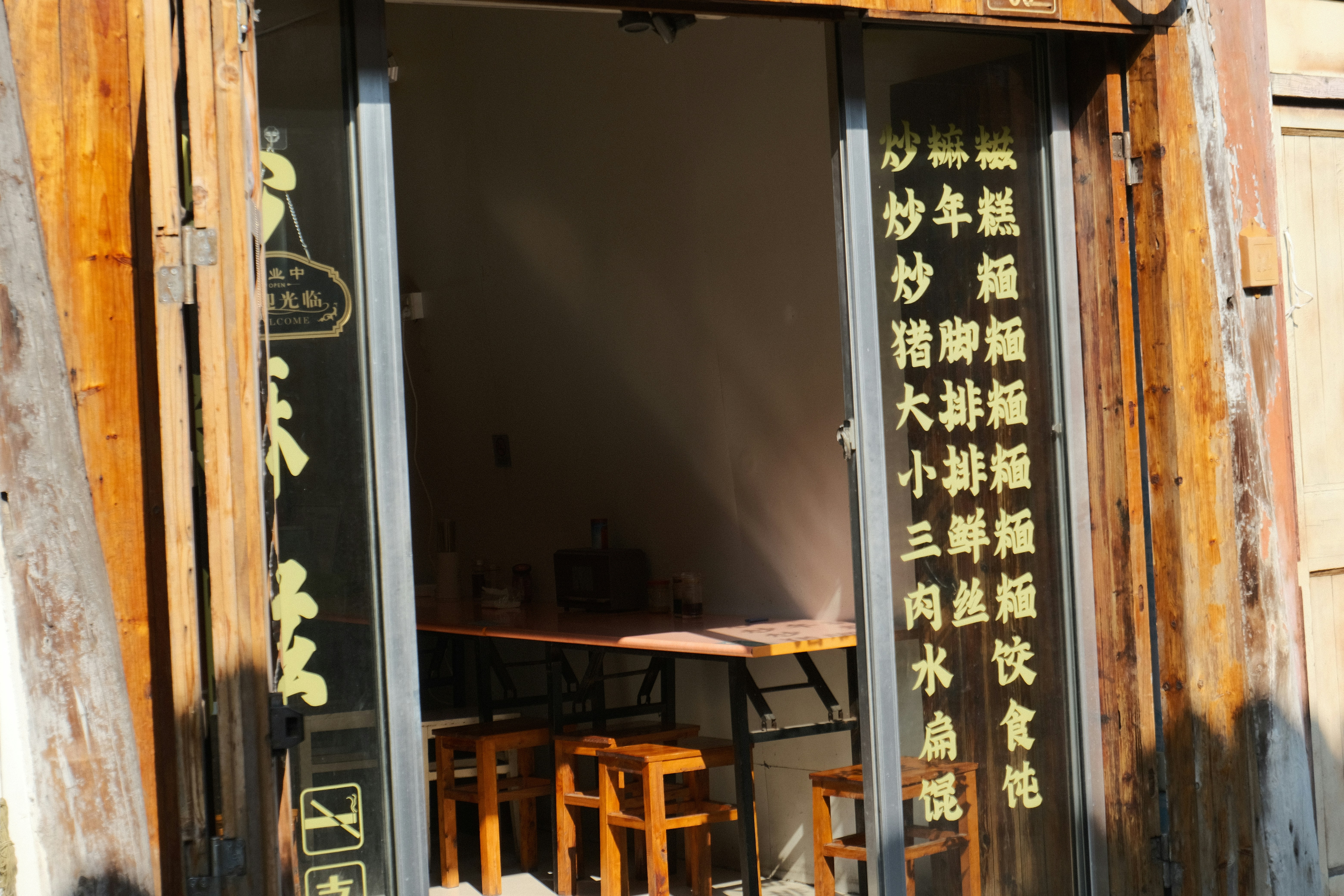 an open door to a restaurant with asian writing on it, A noodle restaurant in China