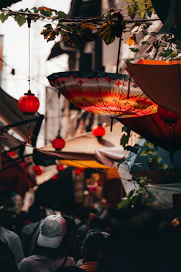 A bustling street market decorated with vibrant lanterns and festive lights.