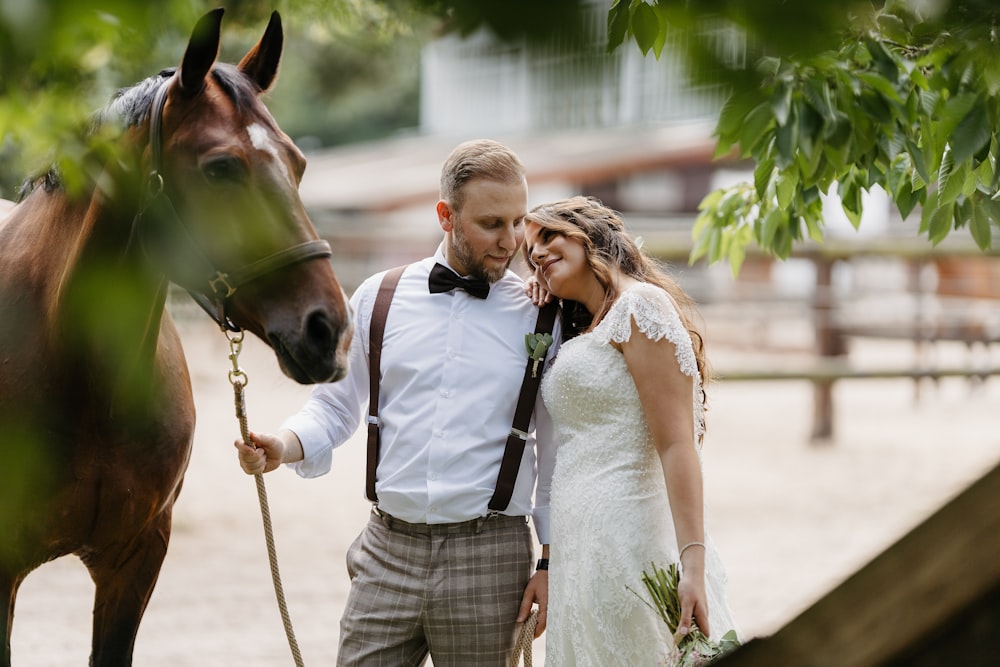 a bride and groom standing next to a horse