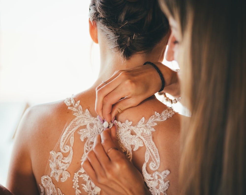 a woman in a wedding dress getting ready for her wedding