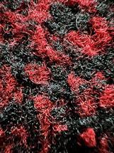 Close-up of black carbon-ceramic composite fibers intertwined against a dark background.