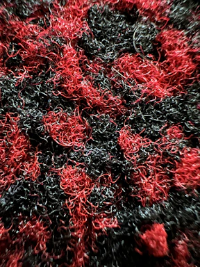 Close-up of black carbon-ceramic composite fibers intertwined against a dark background.