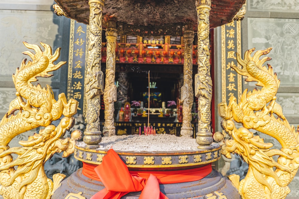 a large golden statue with a red ribbon around it