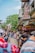 a group of people walking down a street next to tall buildings