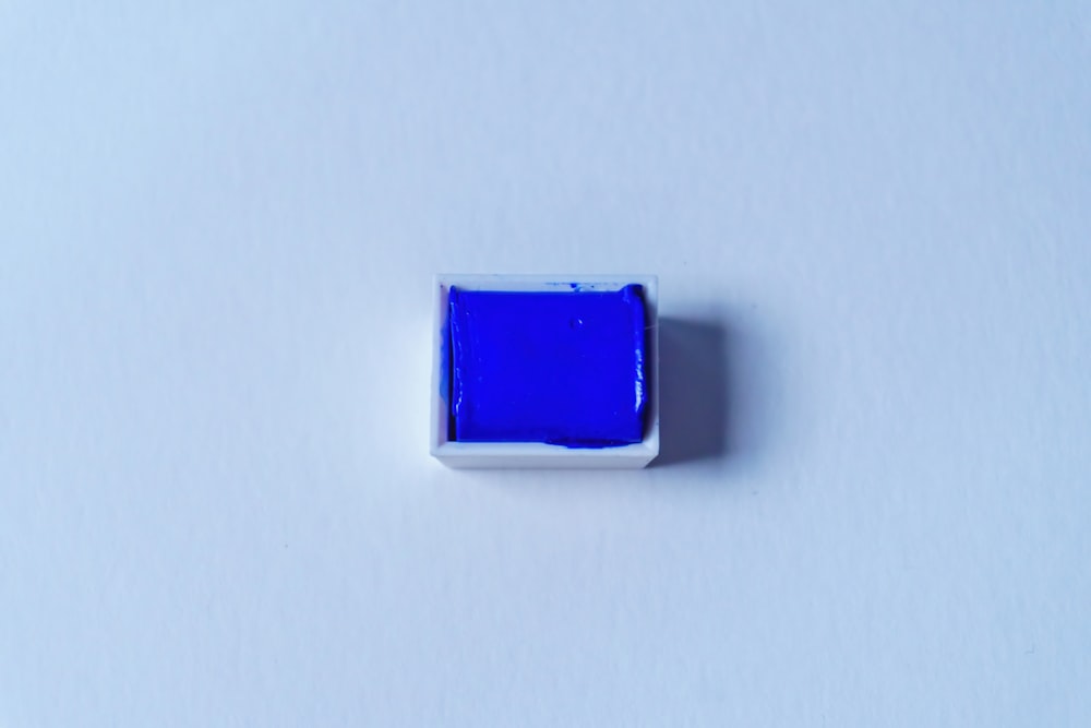 a square blue object sitting on top of a white surface
