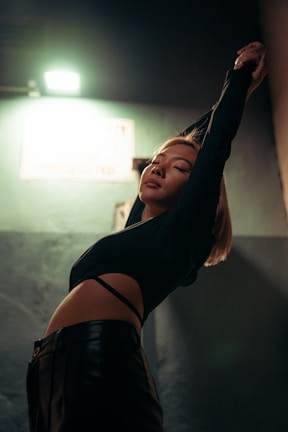 A dynamic shot of a woman stretching in a modern fitness look from geo closet, with soft natural light.