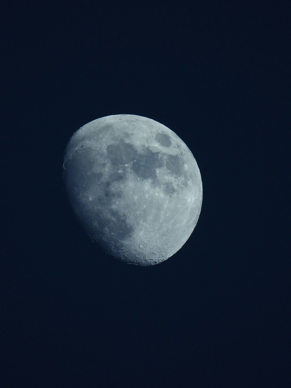 a full moon is seen in the dark sky