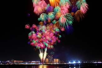 Colorful fireworks bursting over a cheering crowd at a lively city festival