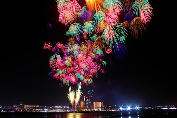 Colorful fireworks bursting over a cheering crowd at a lively city festival