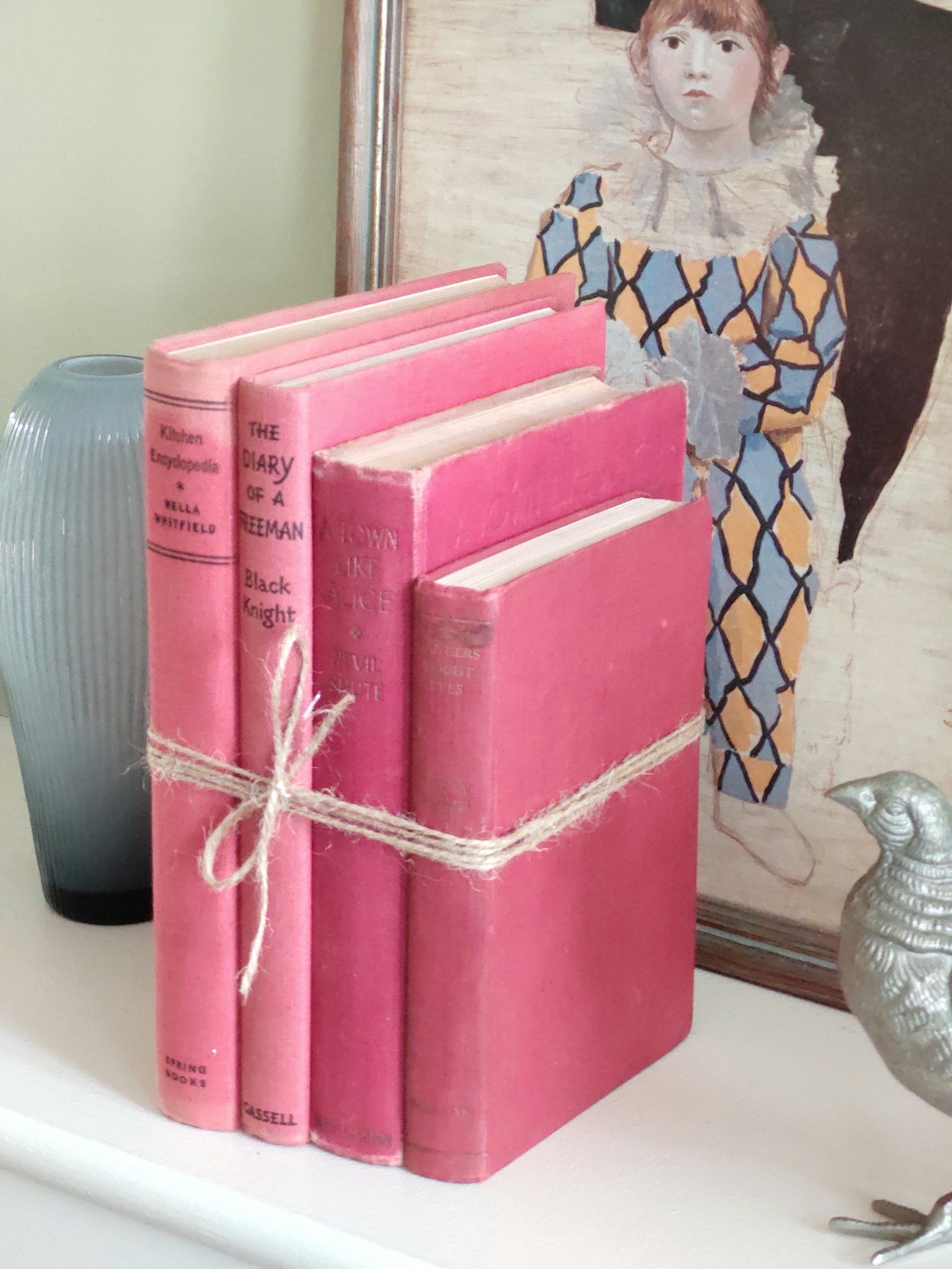 a couple of pink books sitting on top of a white shelf