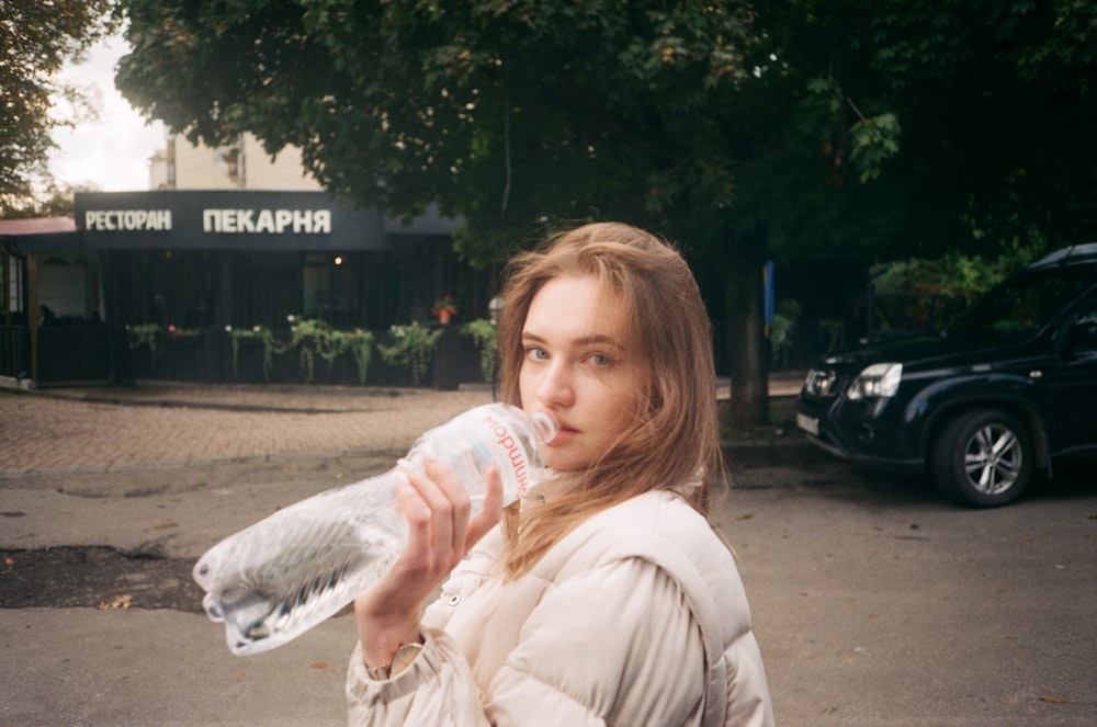 a woman holding a bottle of water in her hand