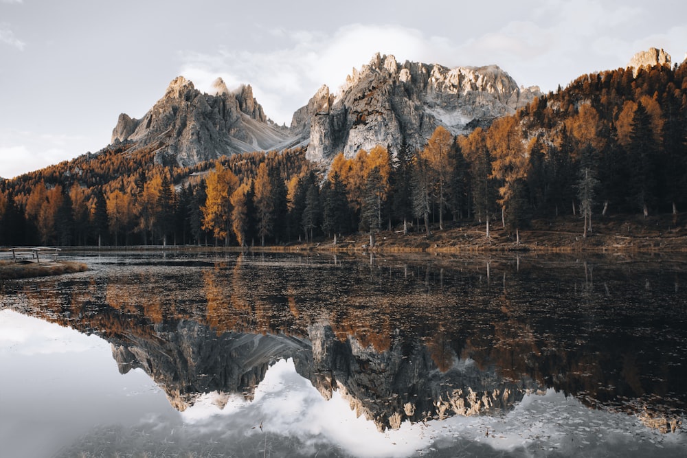 a mountain range is reflected in the still water of a lake