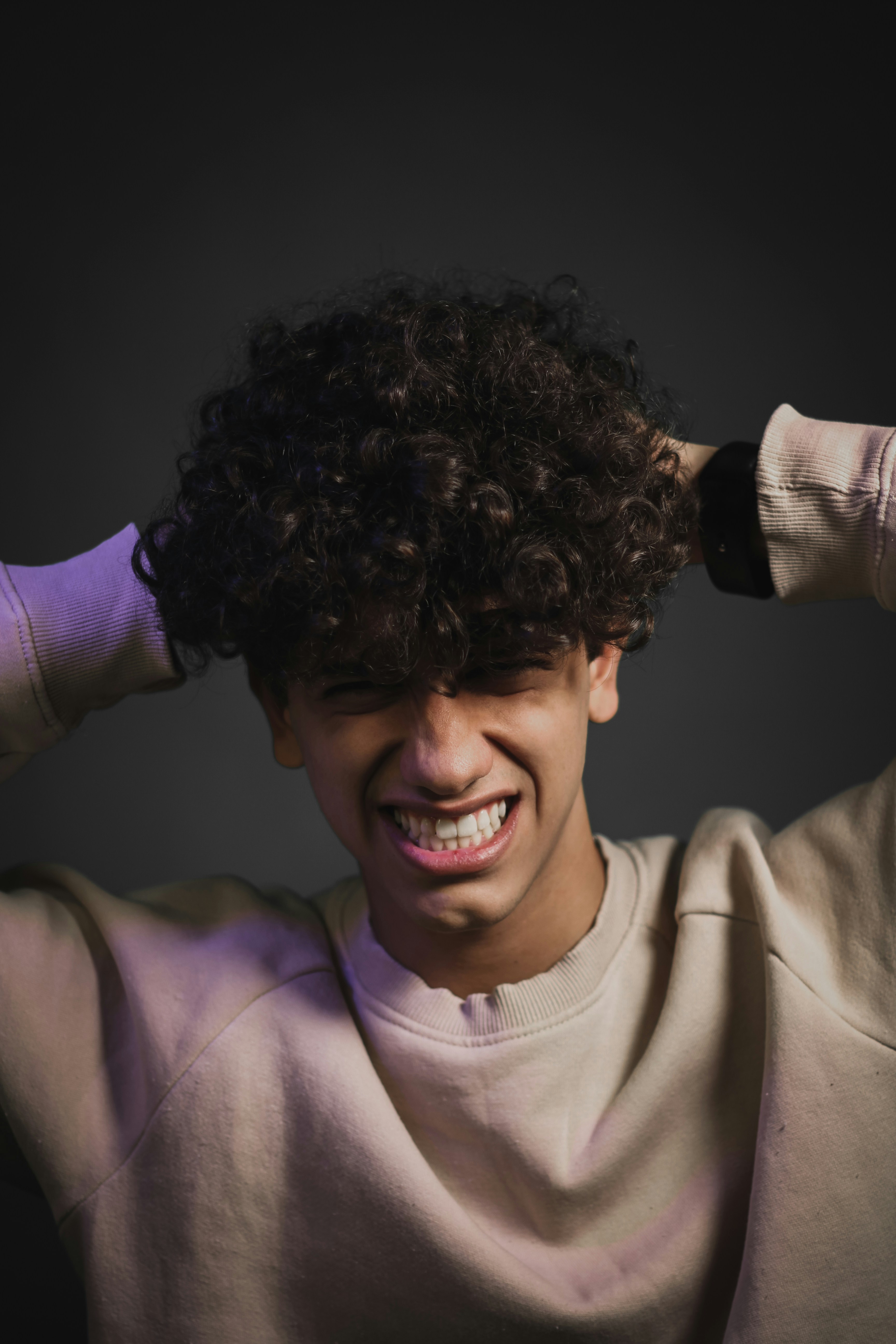 a young man with curly hair is smiling