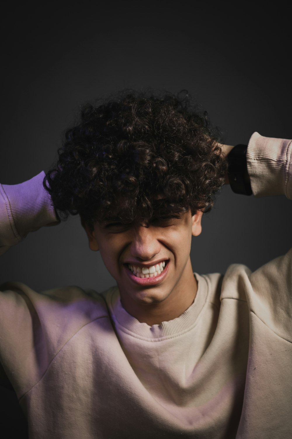 a young man with curly hair is smiling