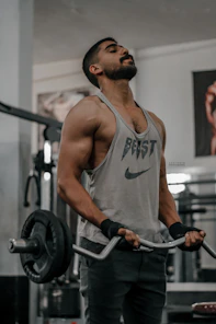 a man holding a barbell in a gym