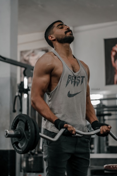 a man holding a barbell in a gym wearing singlet
