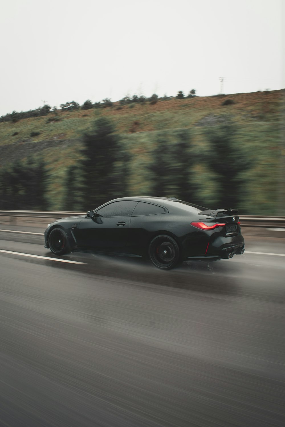 a black sports car driving down a highway