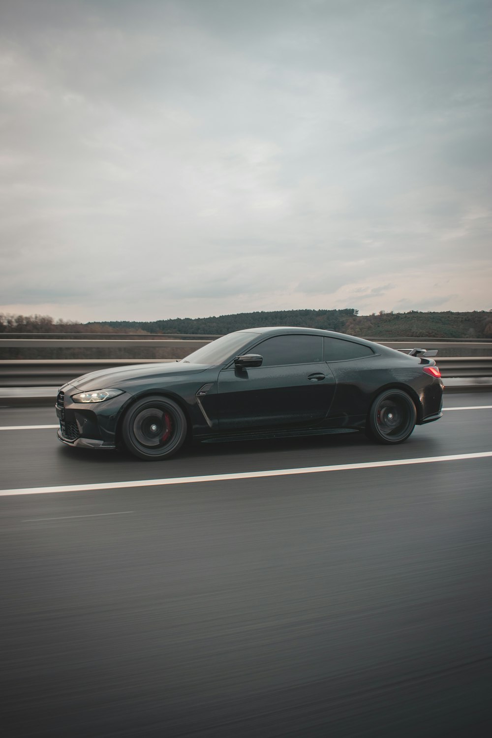 a black sports car driving down a highway