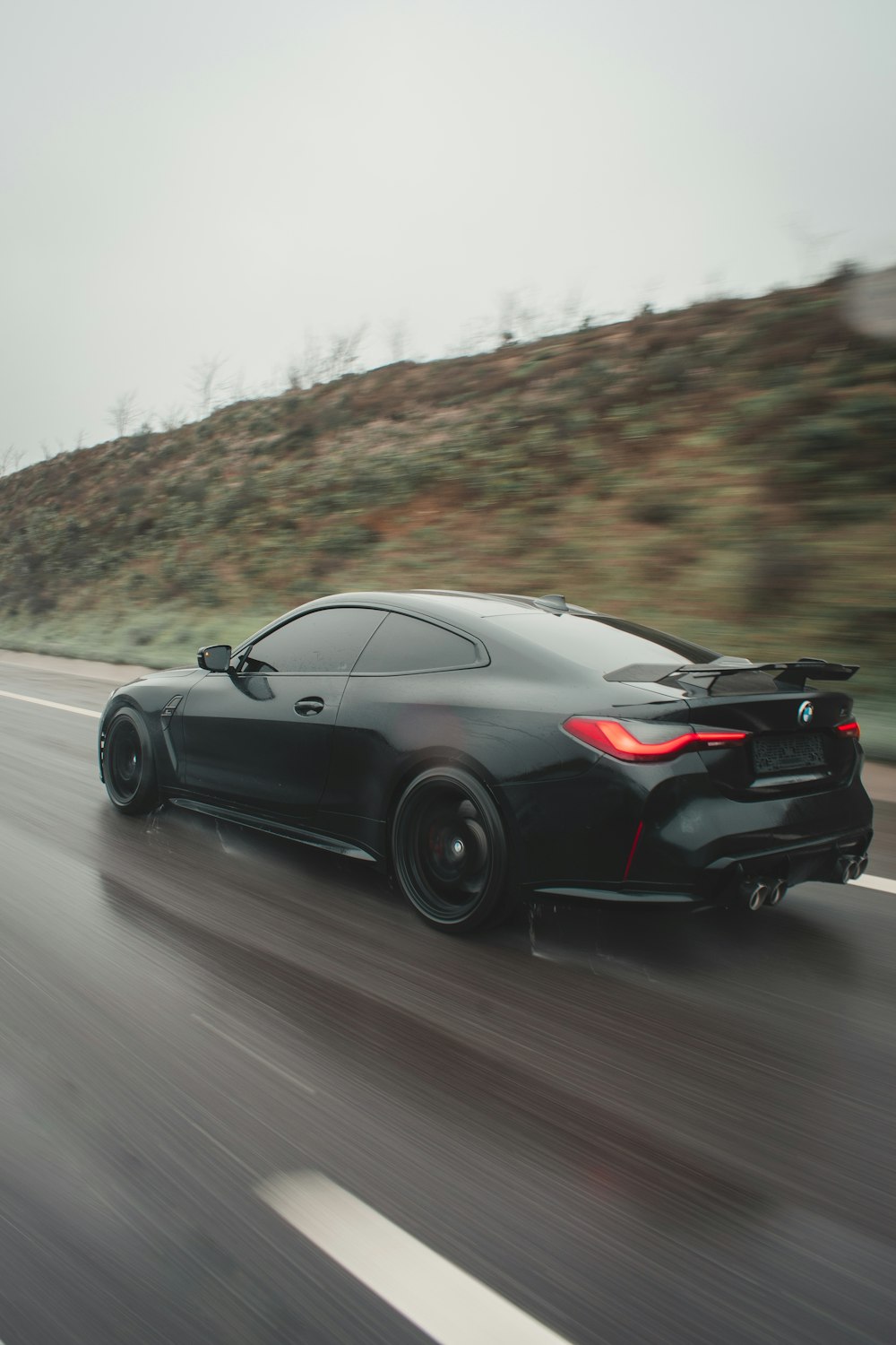 a black sports car driving down the road