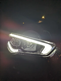 Headlight restoration before and after with clear, bright lenses contrasted against a dark background
