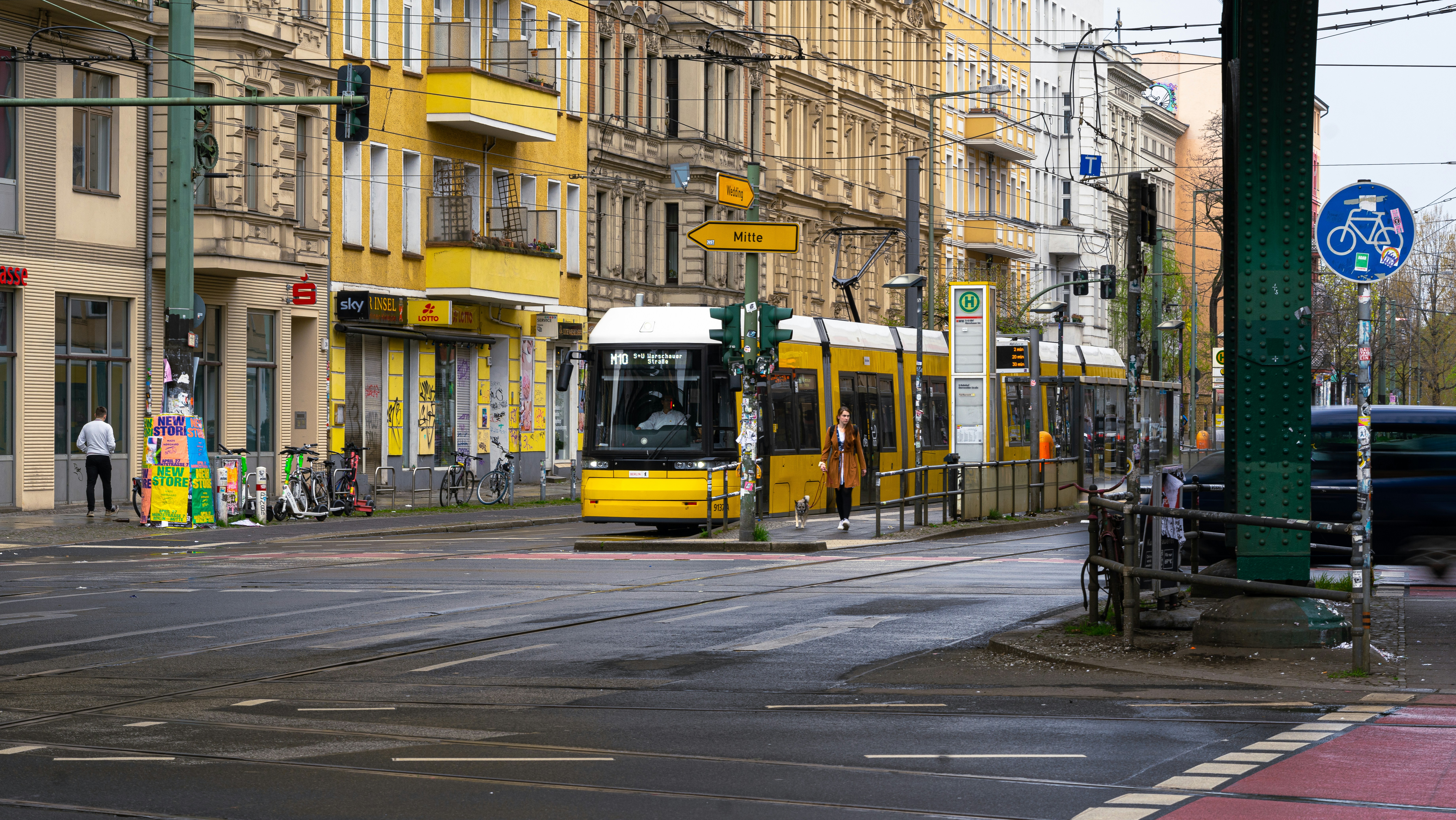 Ein gelber Bus, der eine Straße neben hohen Gebäuden hinunterfährt
