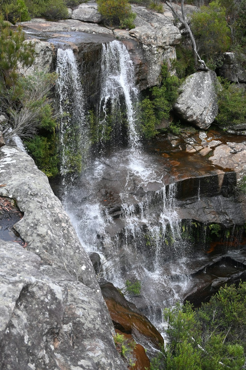 a small waterfall in the middle of a rocky area