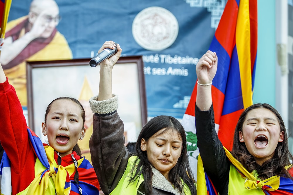 a group of people holding up flags and microphones